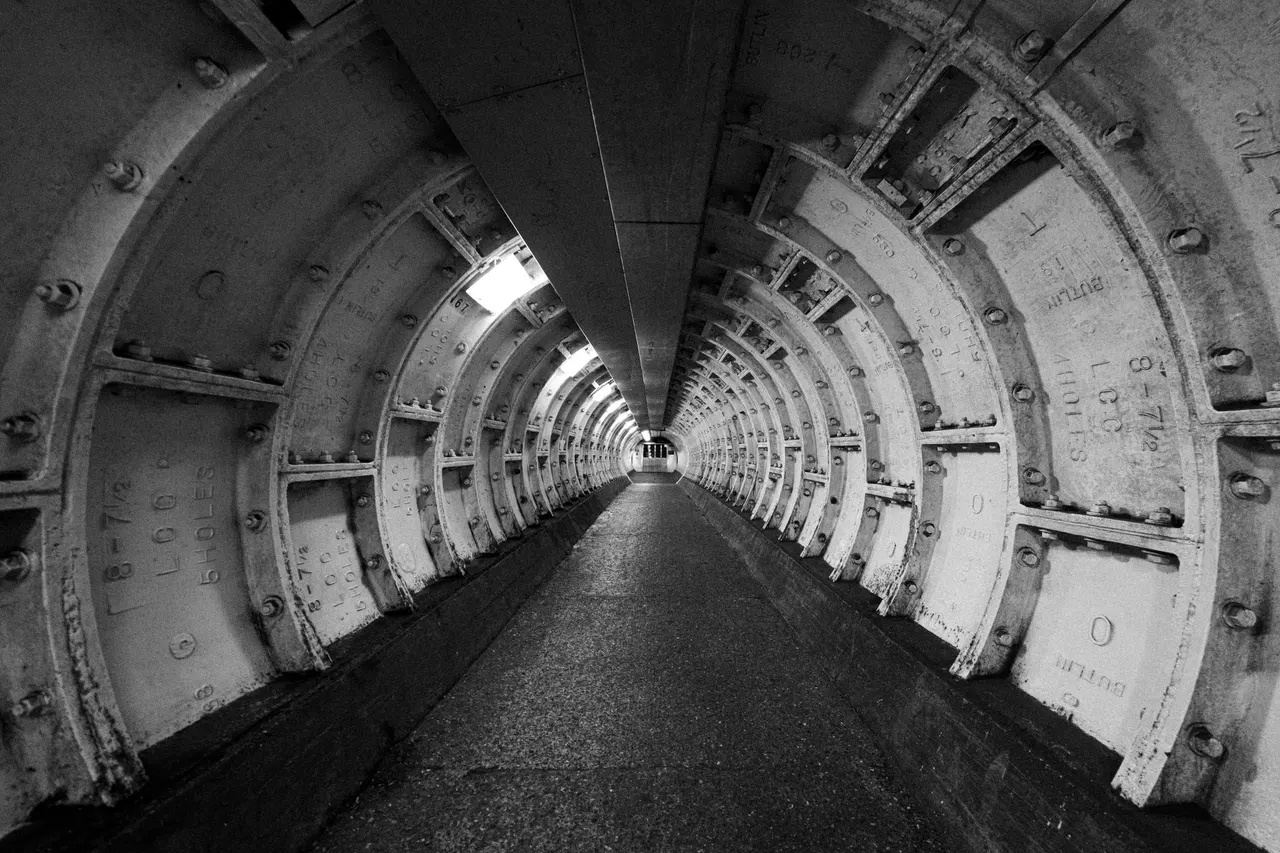 Greenwich foot tunnel, riveted cast-iron rings running into the distance, black and white