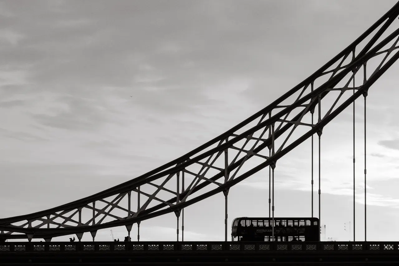 Tower Bridge en contre-jour, un bus à impériale en silhouette, noir et blanc