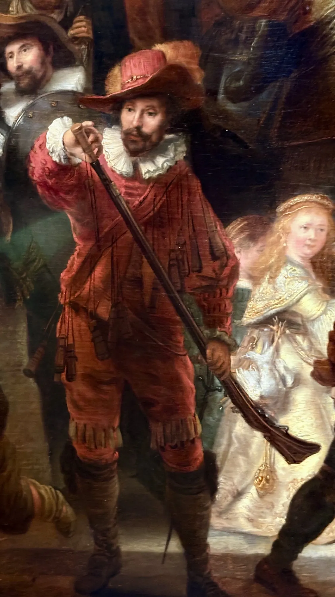 Musketeer in red loading his weapon and the girl in gold, detail from The Night Watch