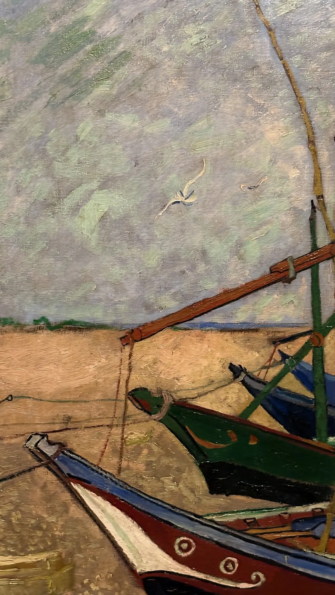 Barques de pêche colorées échouées sur le sable, mâts et cordages