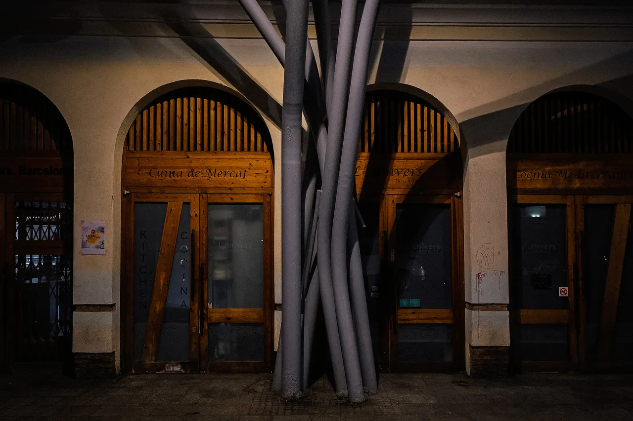 Portes en arc et piliers métalliques, le soir