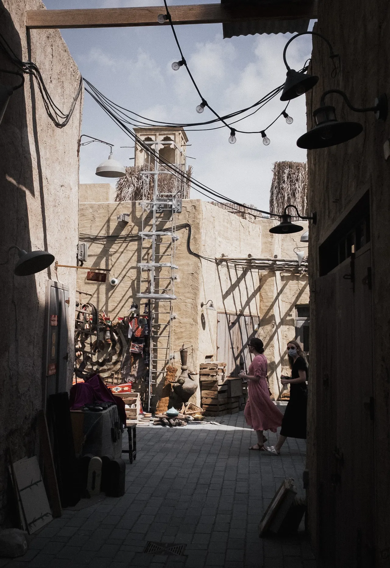 Old-town alley, string lights and a wind tower