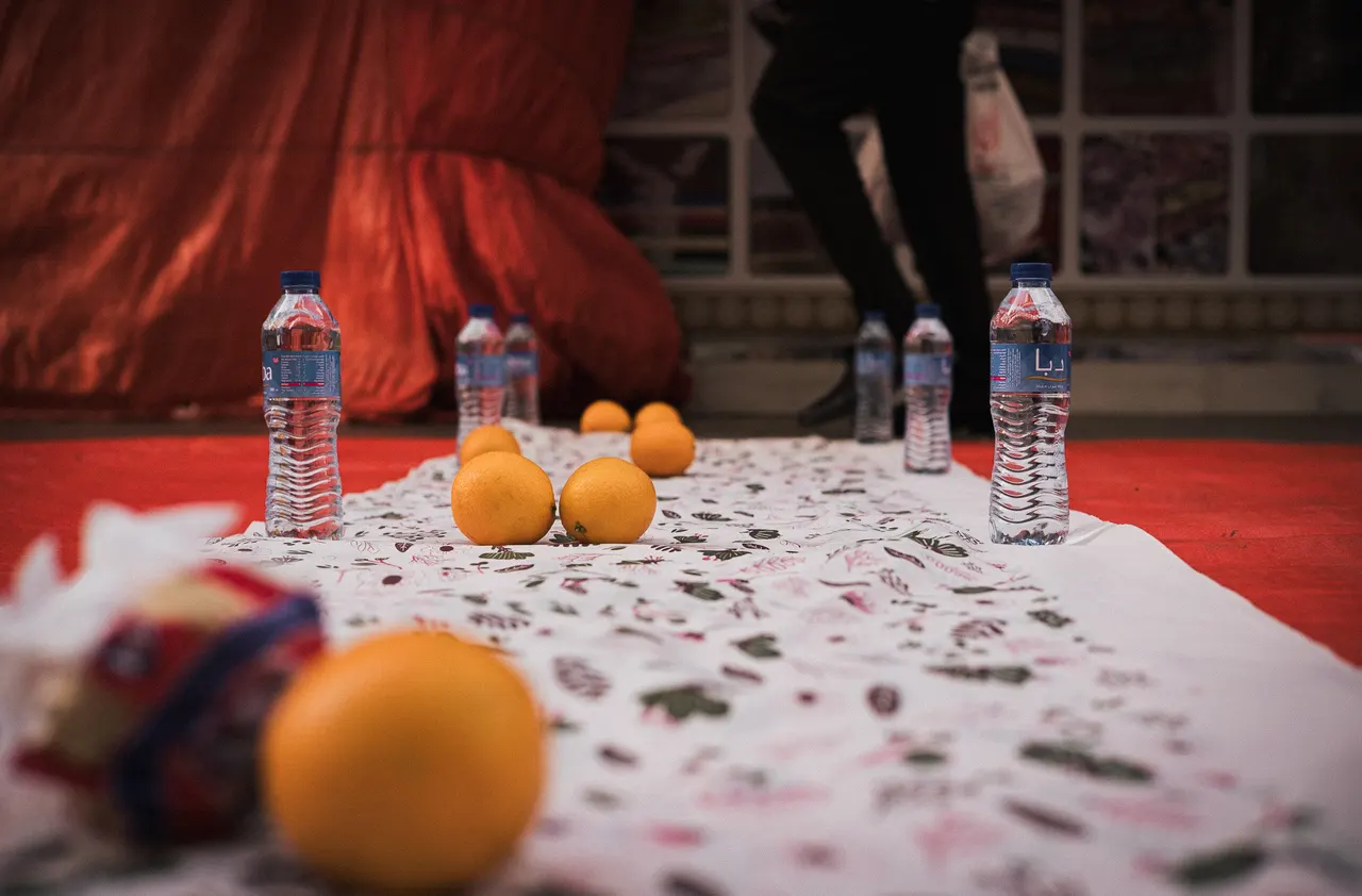 Iftar cloth on the ground, oranges and water bottles