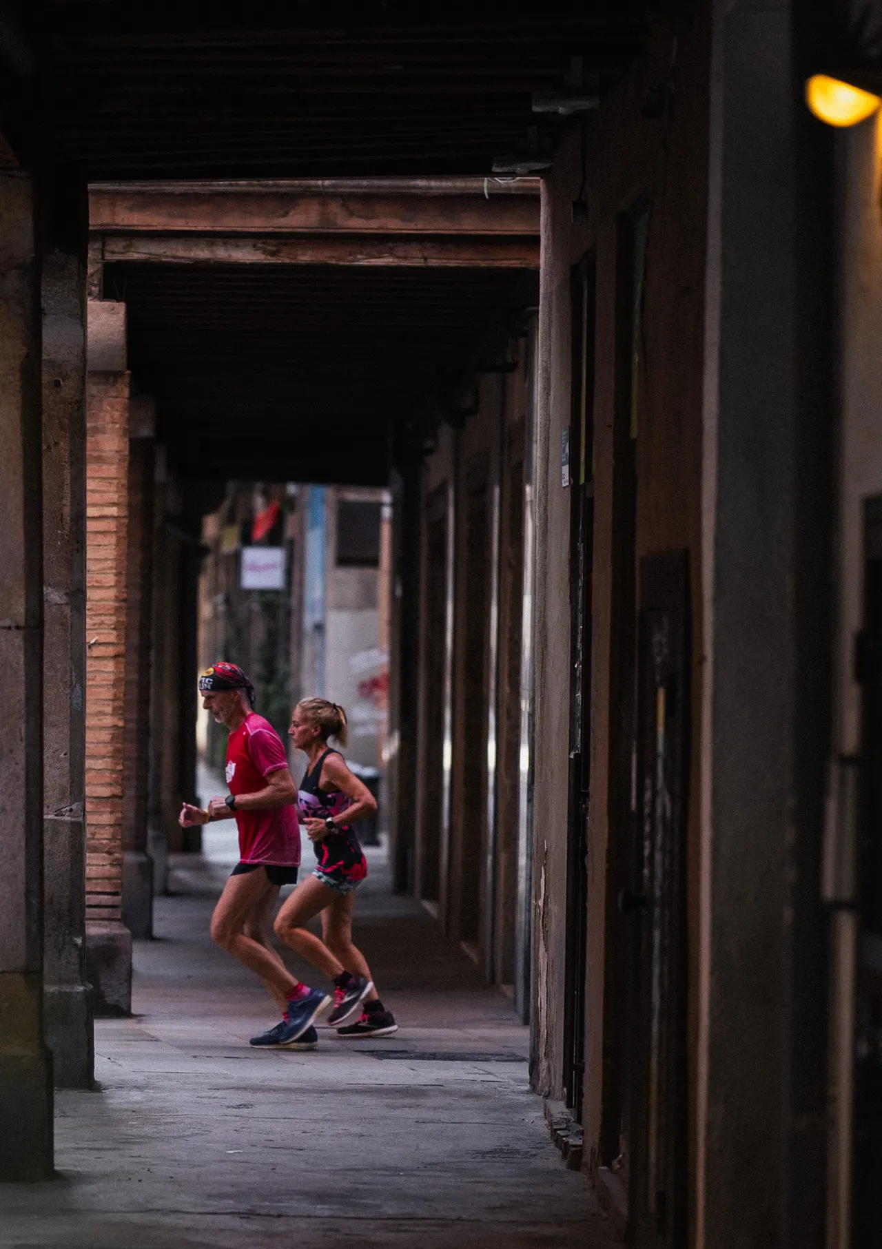 Deux coureurs sous une arcade sombre