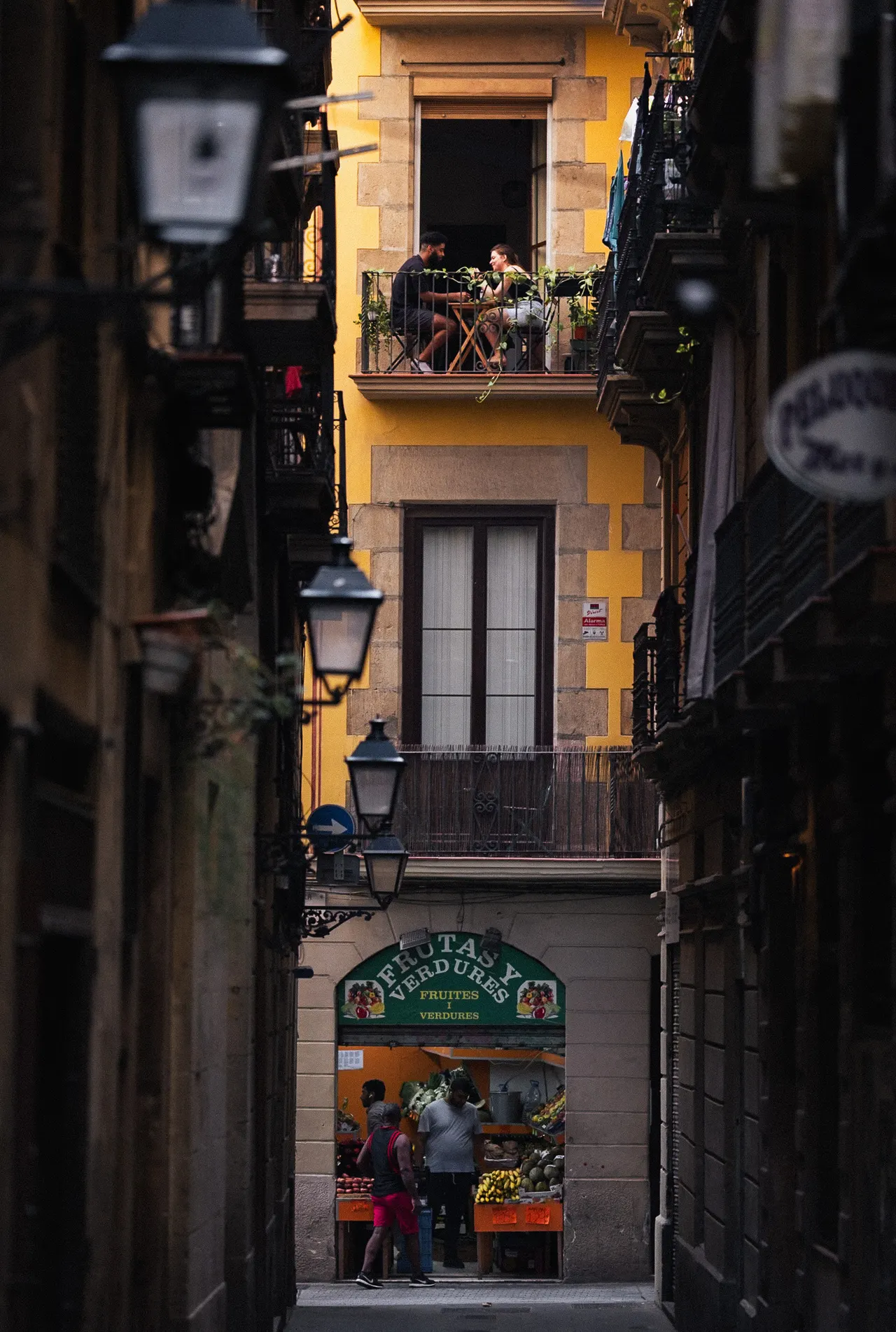 Façade jaune au fond d'une ruelle, un primeur au rez-de-chaussée