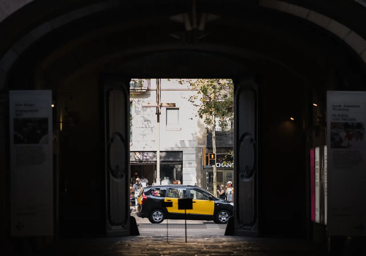 Taxi noir et jaune cadré par une porte sombre