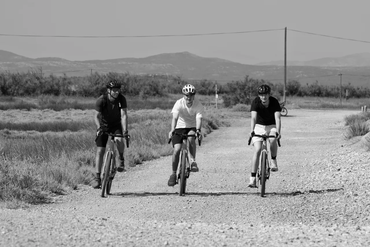 Groupe de cyclistes sur les pistes gravel, paysage des étangs, Gruissan