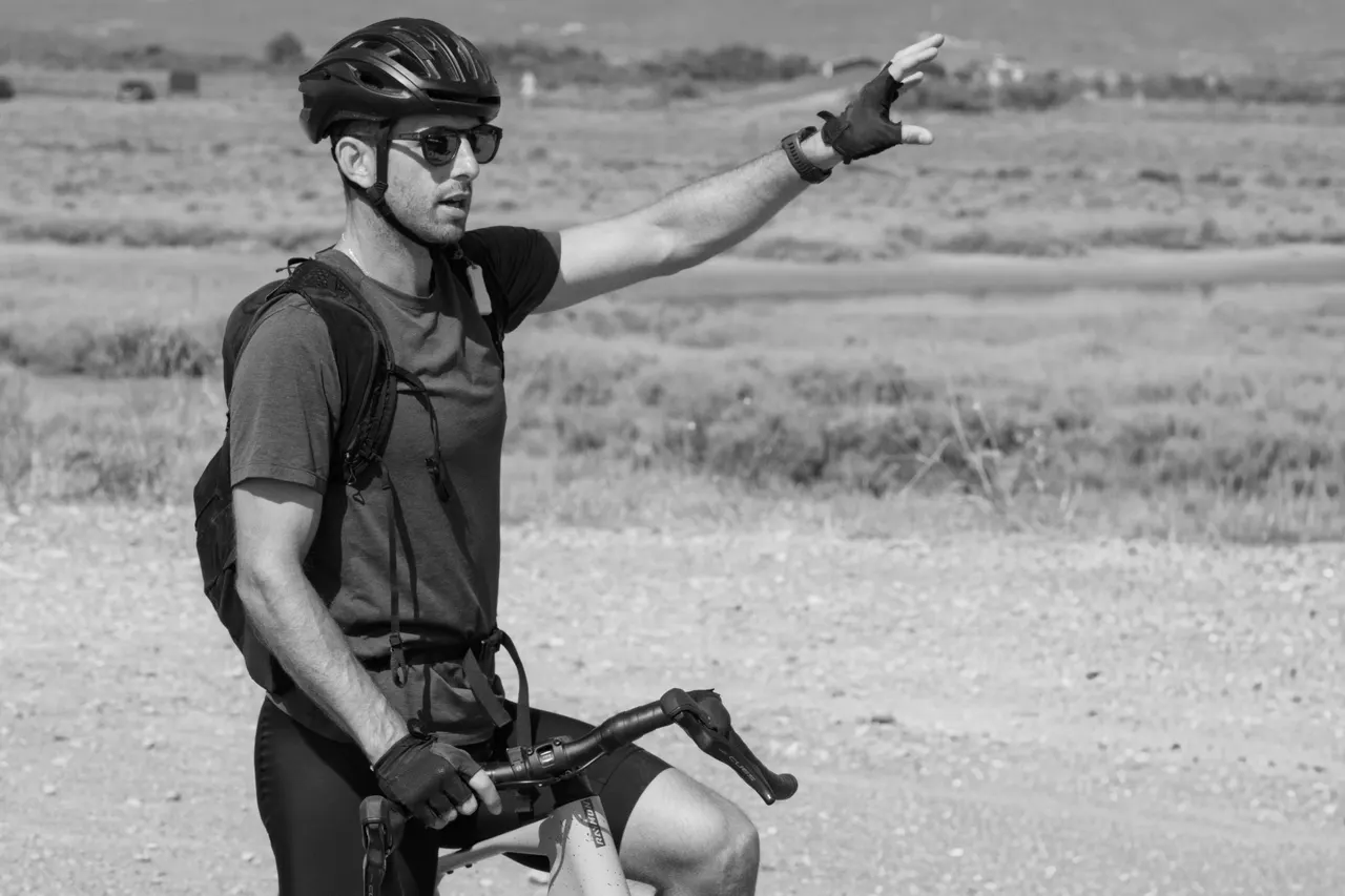 Cycliste faisant signe de la main sur une piste gravel, Gruissan