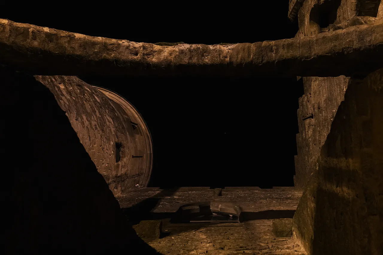 Tour ronde encadrée par une poutre de pierre, la nuit