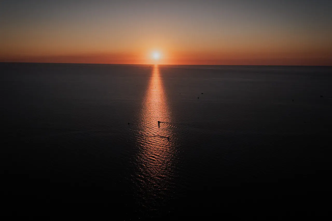 Sunset over the sea, reflected in the water